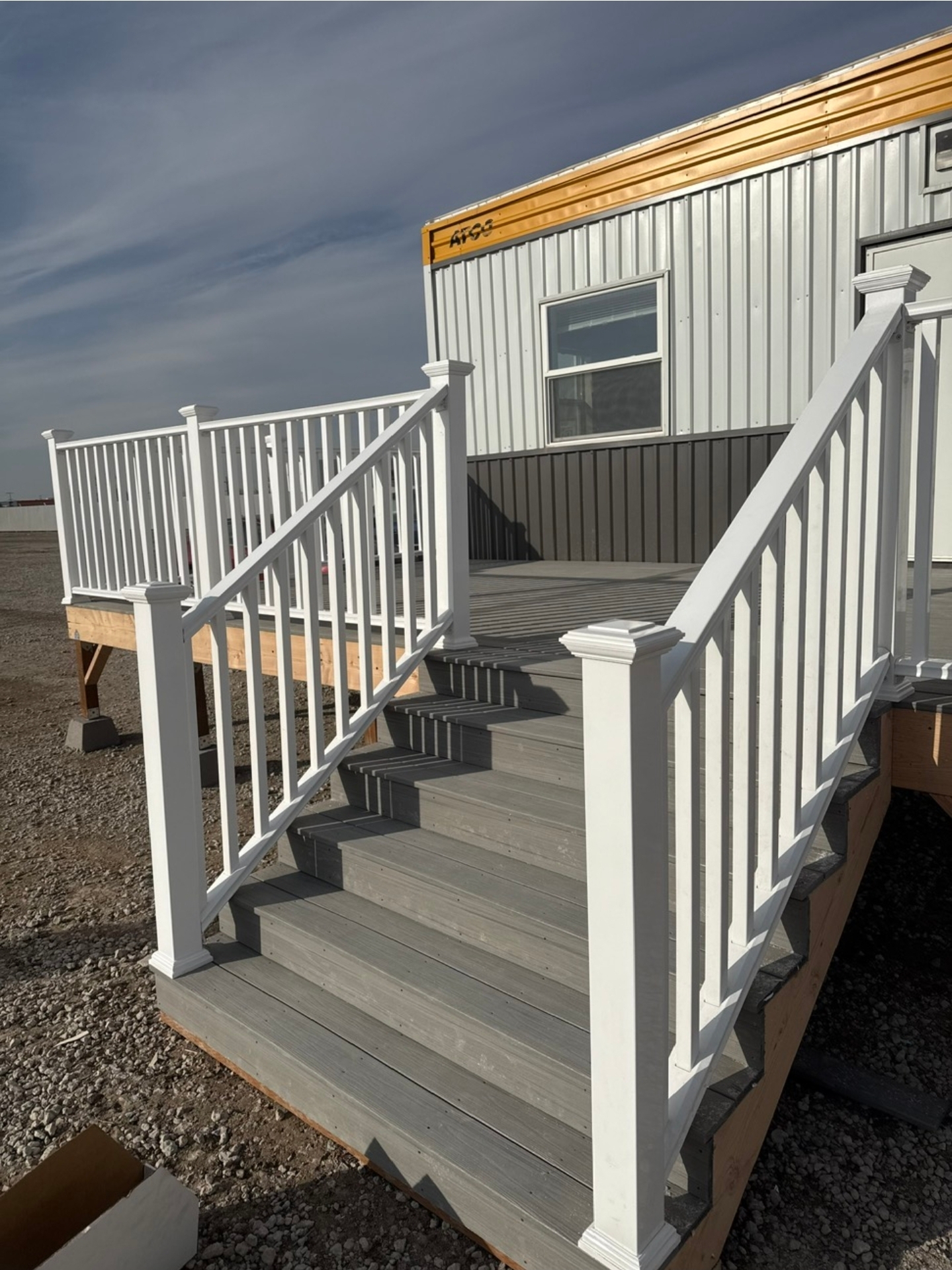 New composite deck and stairs with white vinyl railing on a residential build