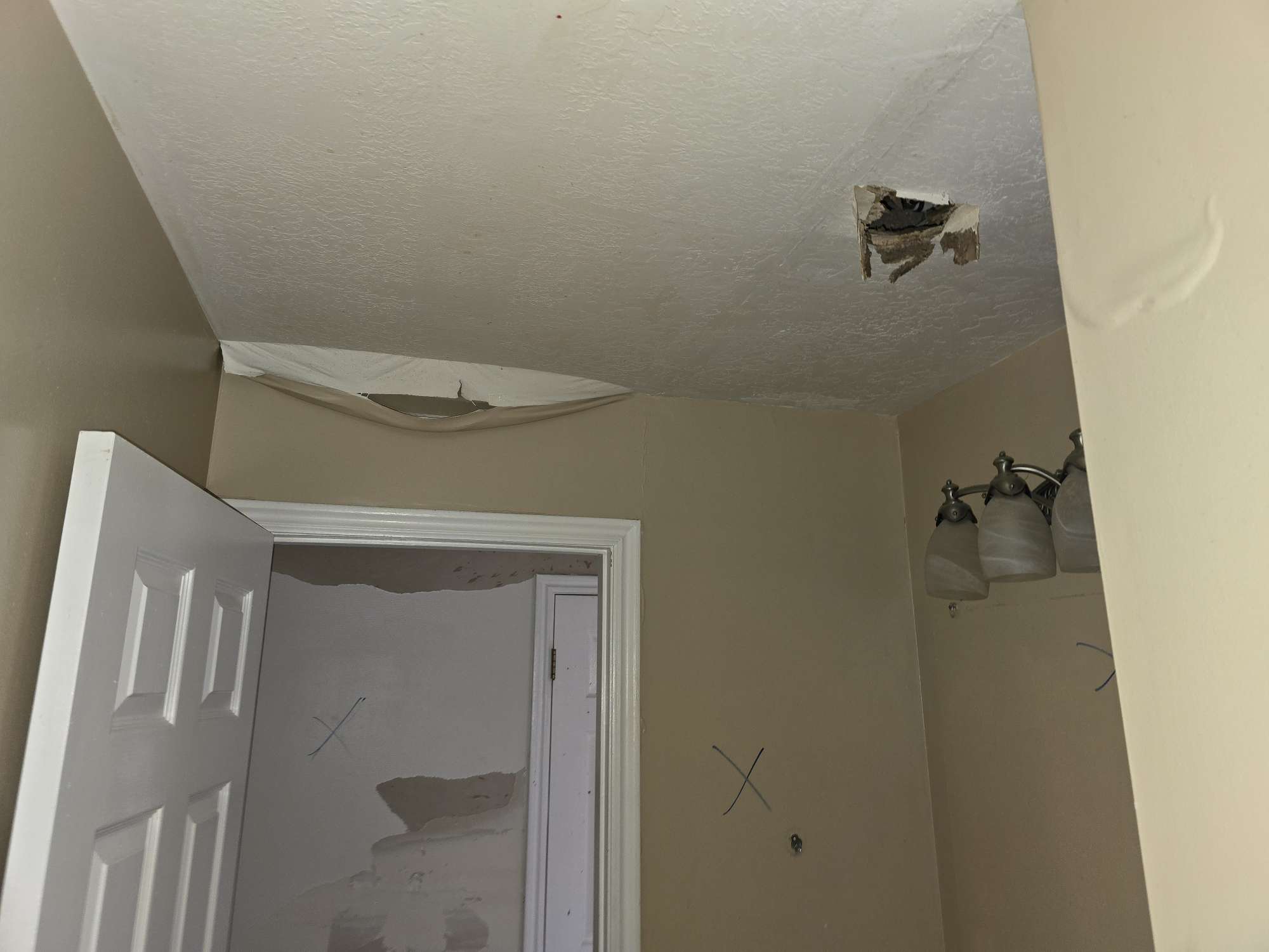 Restoration technician in PPE deodorizing smoke-damaged living room
